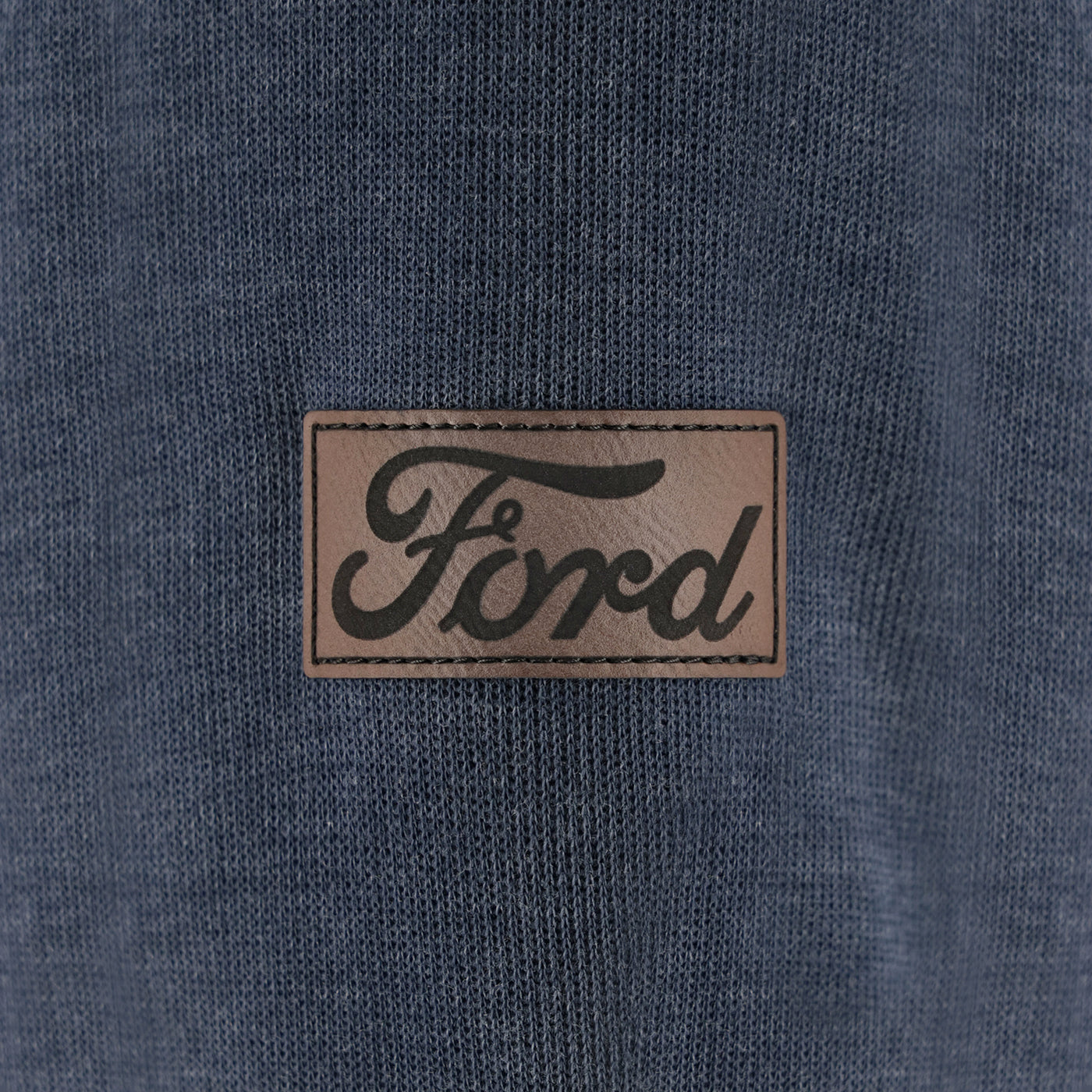 Close-up of a Ford logo patch on a blue fabric background