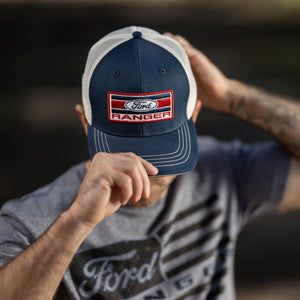 man in a gray ranger shirt wearing a navy blue hat with an americana ford ranger patch