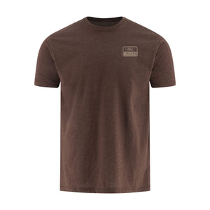 A brown short-sleeve crewneck t-shirt with a small rectangular 'TRUCKS' logo patch on the left chest, displayed on a clean white background.