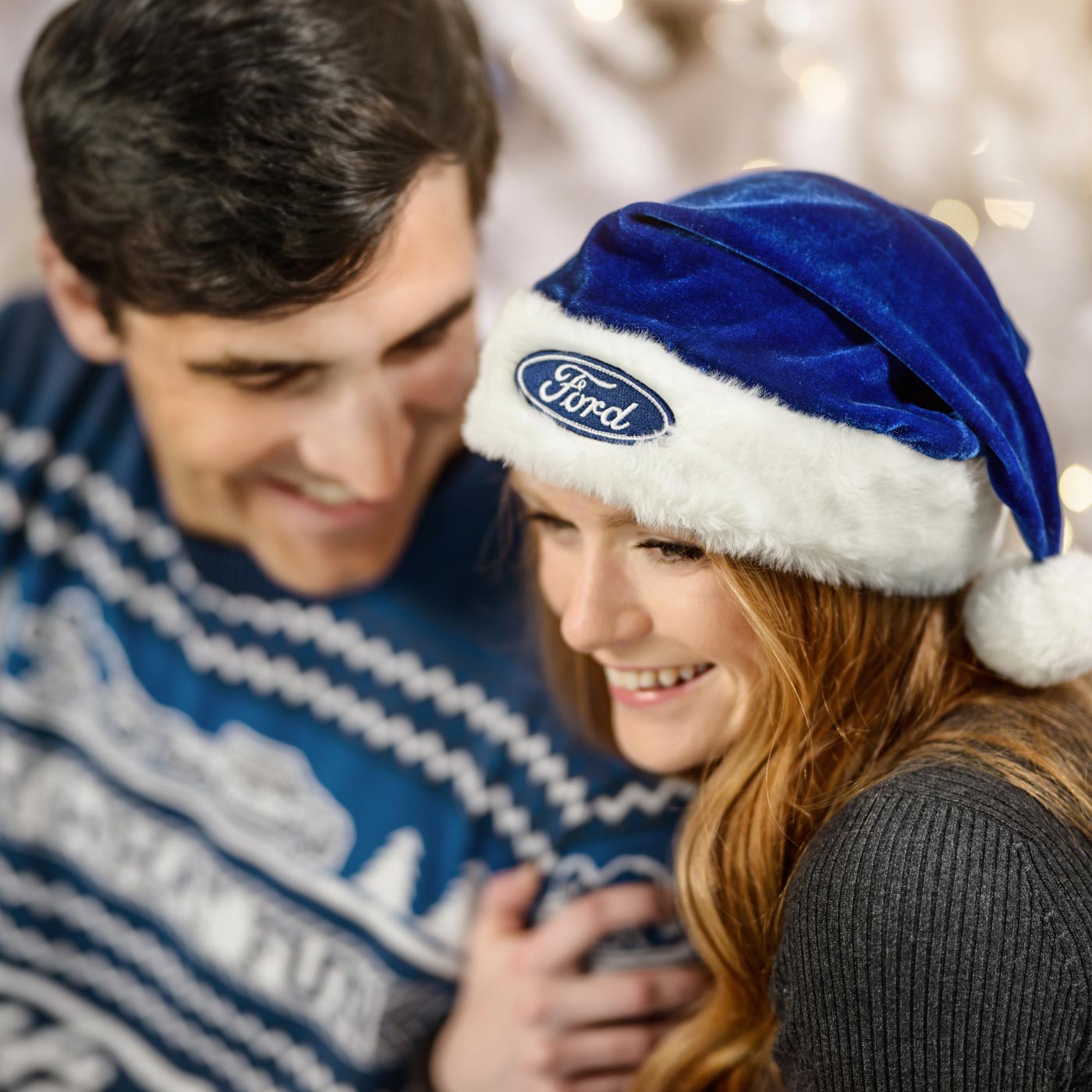 Person wearing a blue Ford logo Santa hat with a blurred background