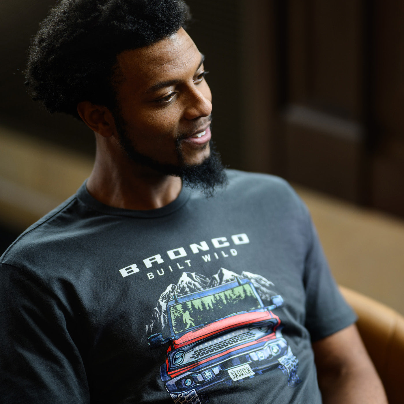 Man wearing a t-shirt with a graphic design of a truck and text.