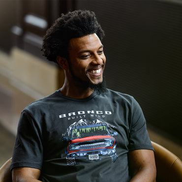 Man wearing a black t-shirt with a graphic design of a truck and 'Bronco Built Wild' text.
