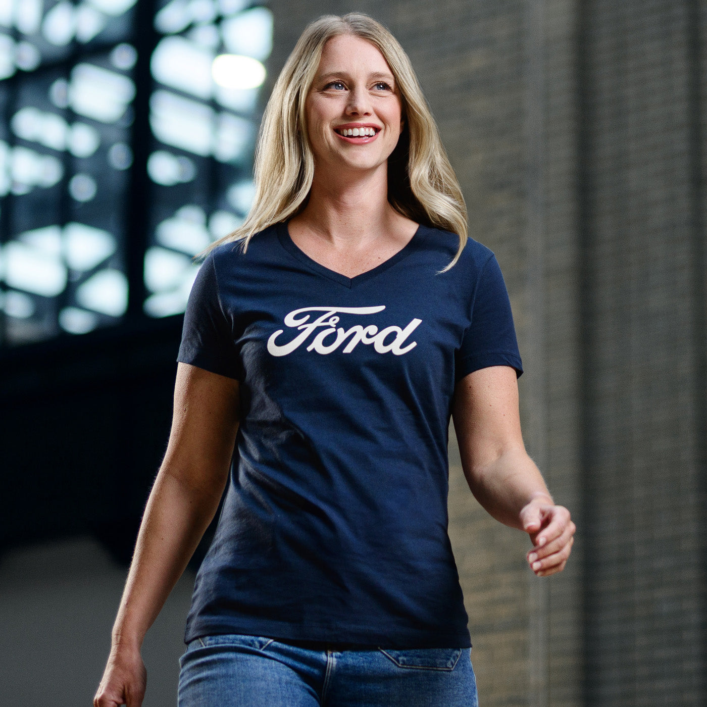Woman wearing a navy blue 'Ford' t-shirt standing indoors.