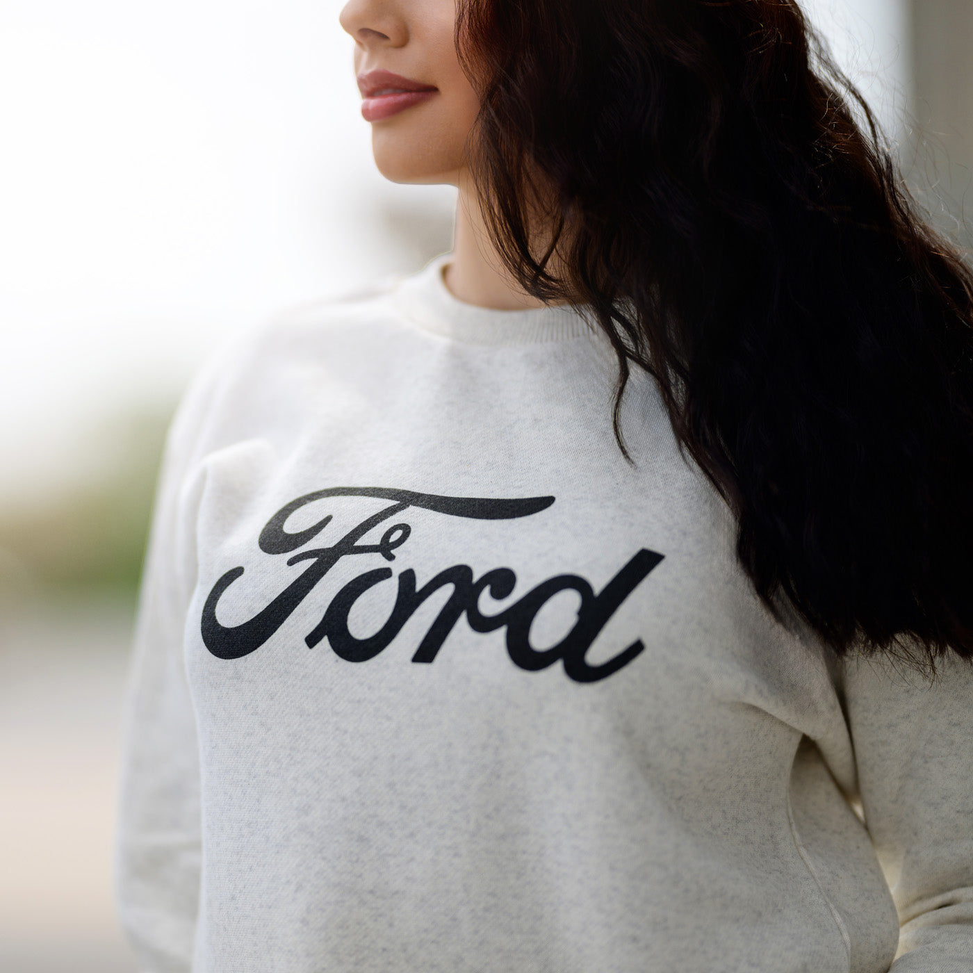 Person wearing a white sweatshirt with 'Ford' printed on it.