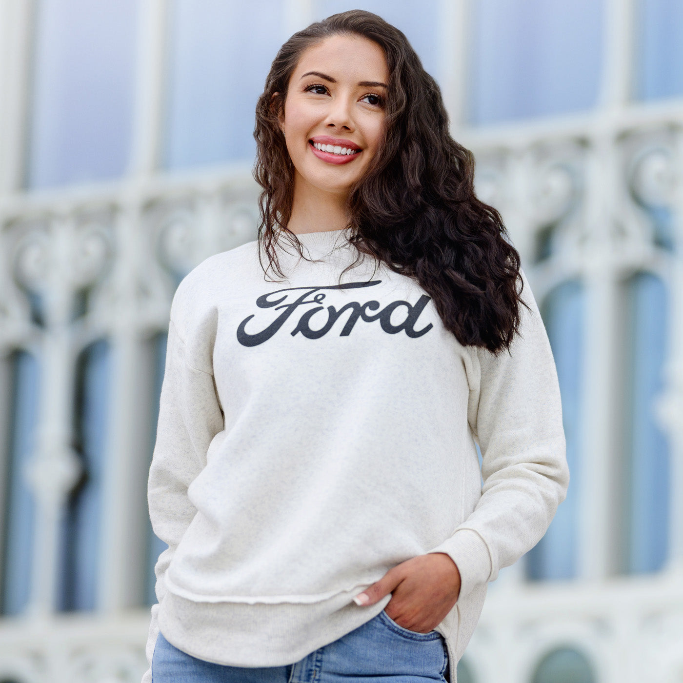 Woman wearing a white sweatshirt with 'Ford' logo outdoors