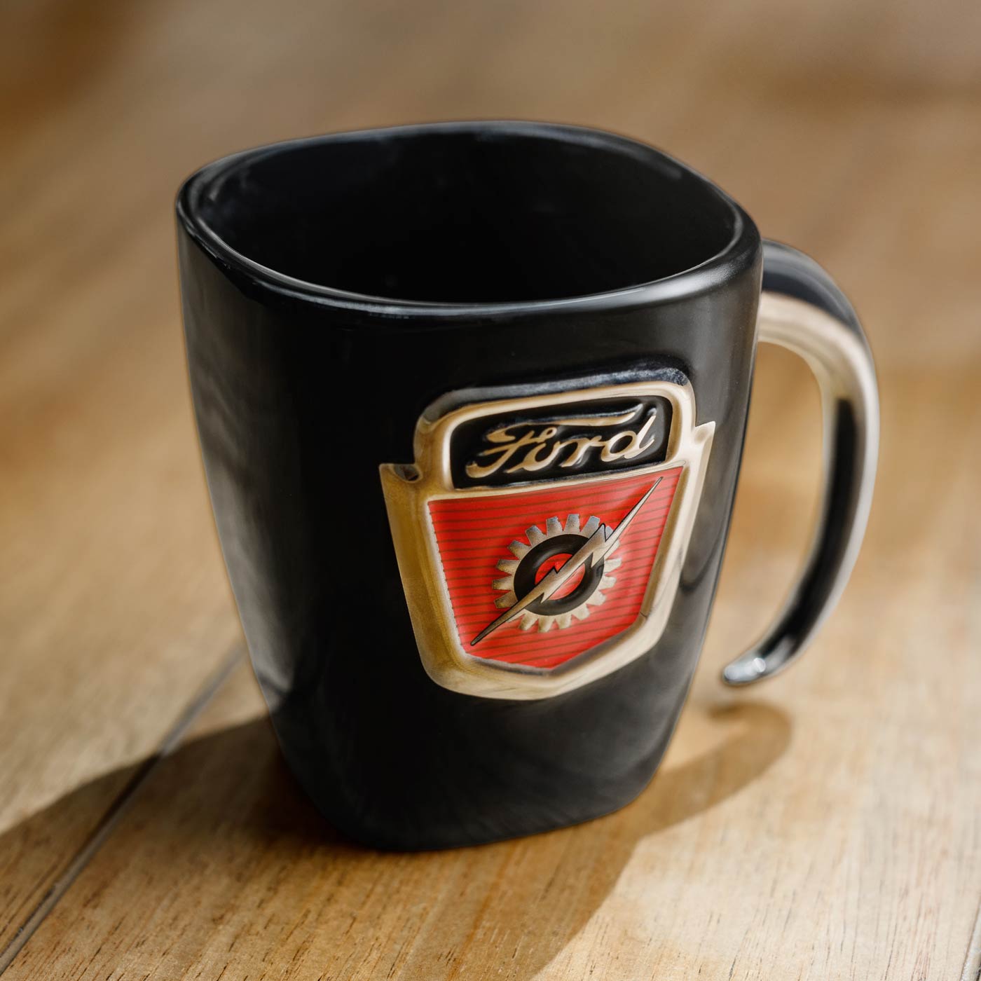 Black mug with Ford logo on a wooden surface