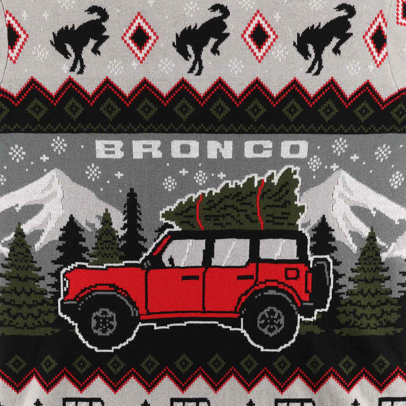 Ugly sweater design with red Bronco truck carrying a Christmas tree, mountains, and trees on a gray background.