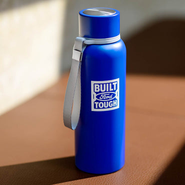 Blue water bottle with 'Built Ford Tough' logo on a brown surface