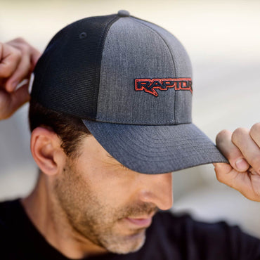 Person wearing a gray and black cap with 'Raptor' logo on a blurred background