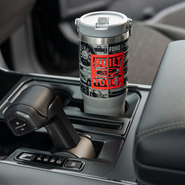 Ford branded tumbler in a car's cup holder with 'Built Ford tough" text.