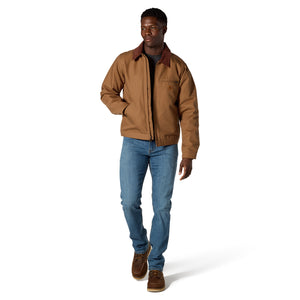 A man modeling a brown utility jacket with a dark brown corduroy collar, paired with blue jeans and brown shoes, on a white studio background.