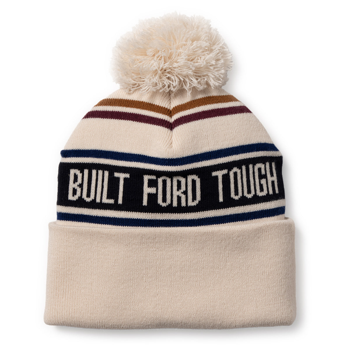 A knit pom-pom beanie hat with a cream base, featuring navy, brown, and navy stripes, a black horizontal band with white text reading 'BUILT FORD TOUGH', and a matching cream cuff.