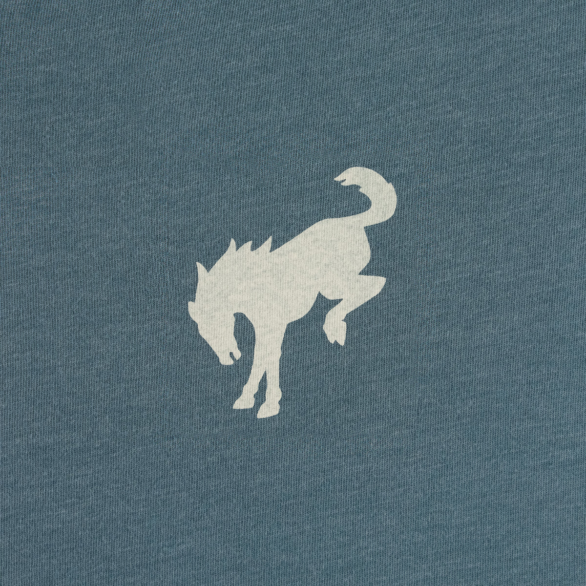 A close-up of a heathered slate blue fabric with a light beige graphic of a horse silhouette.