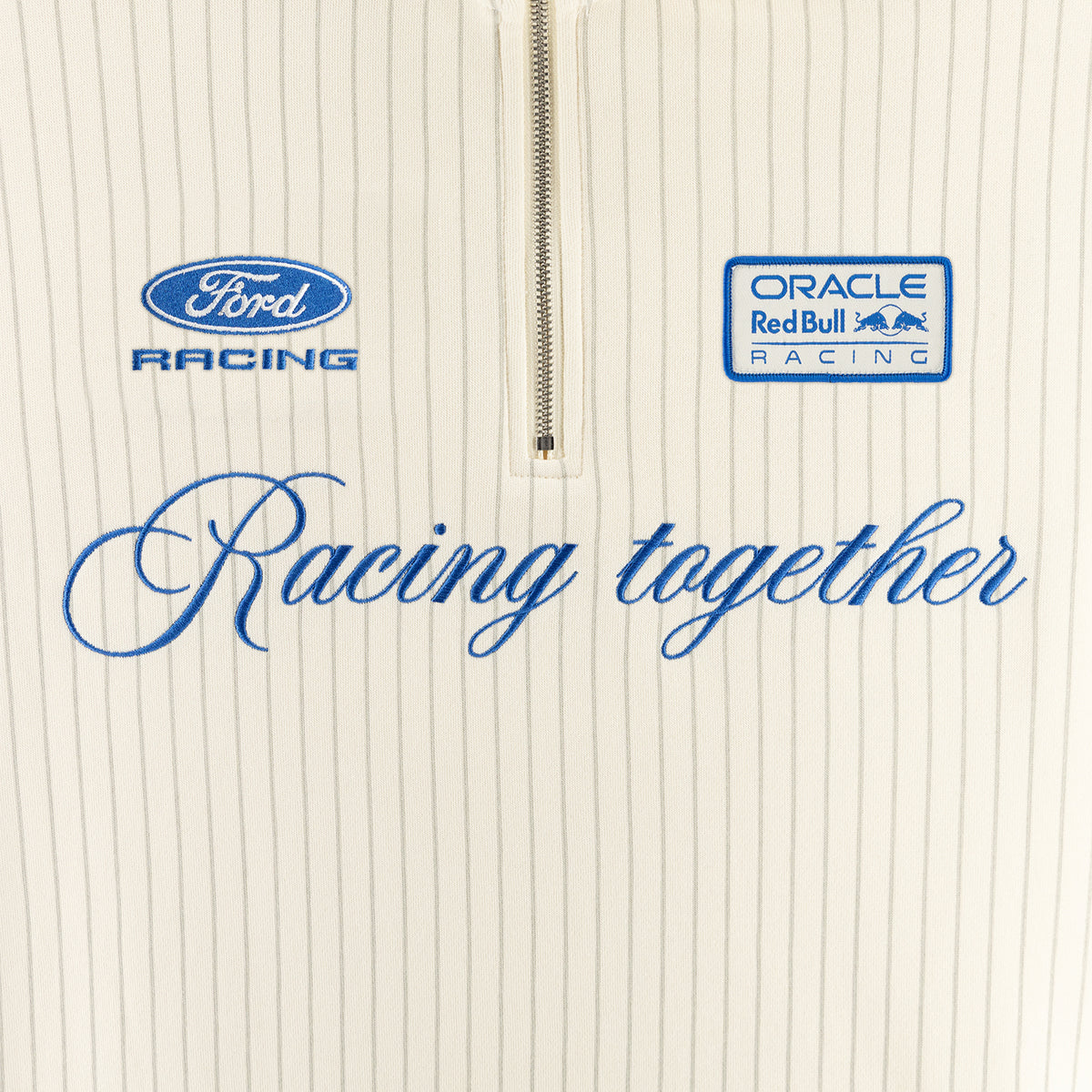 Close-up of a cream pinstriped zip-up garment with blue Ford Racing and Oracle Red Bull Racing logos and the phrase 'Racing together' across the front.