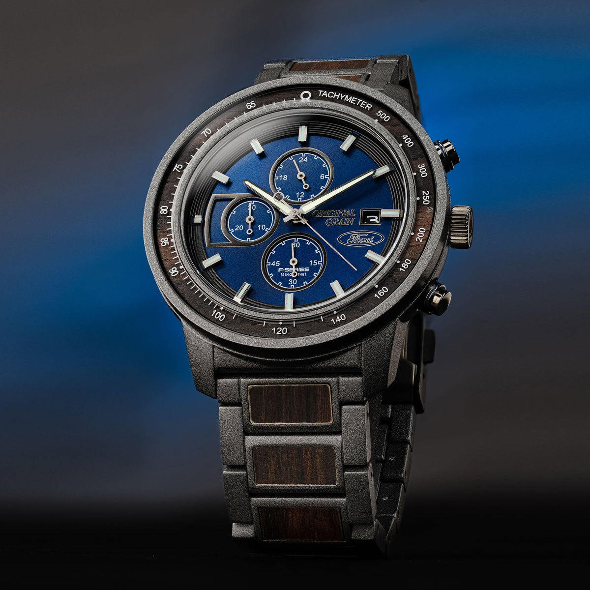 Luxury watch with blue dial and black strap on a gradient blue and black background