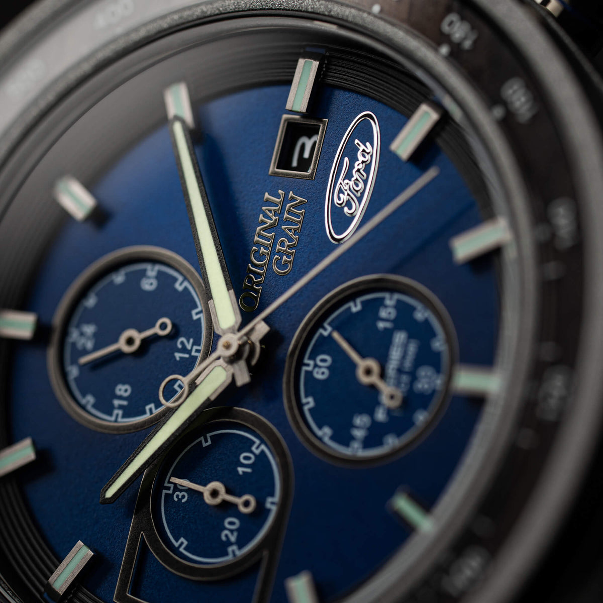 Close-up of a blue watch face with 'Original Grain' branding