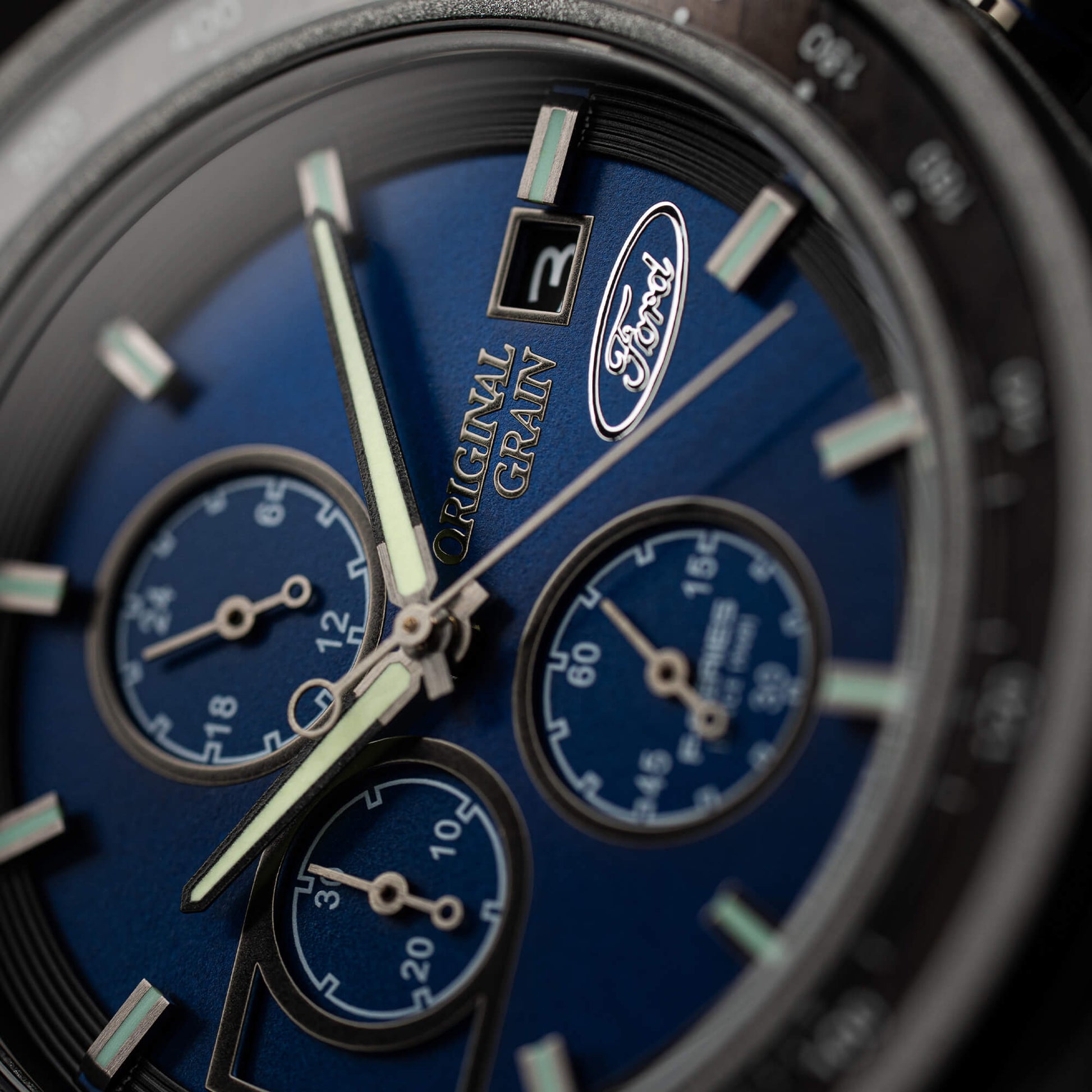 Close-up of a blue watch face with 'Original Grain' branding
