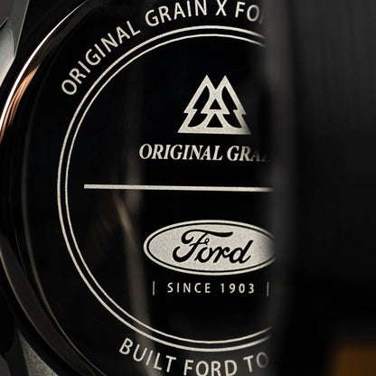 Close-up of a Ford logo with 'Original Grain' text on a dark background