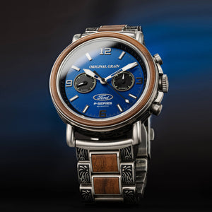 Luxury watch with blue face and wooden accents on a dark background
