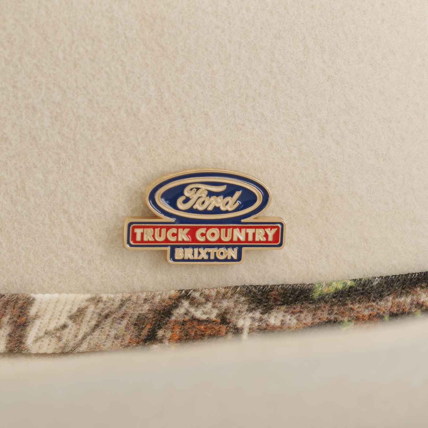Ford logo on a cap with 'Truck Country Brixton' text, featuring a camouflage band.