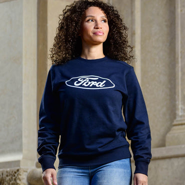 women with curly black hair standing in navy blue sweatshirt with white for script and oval on front