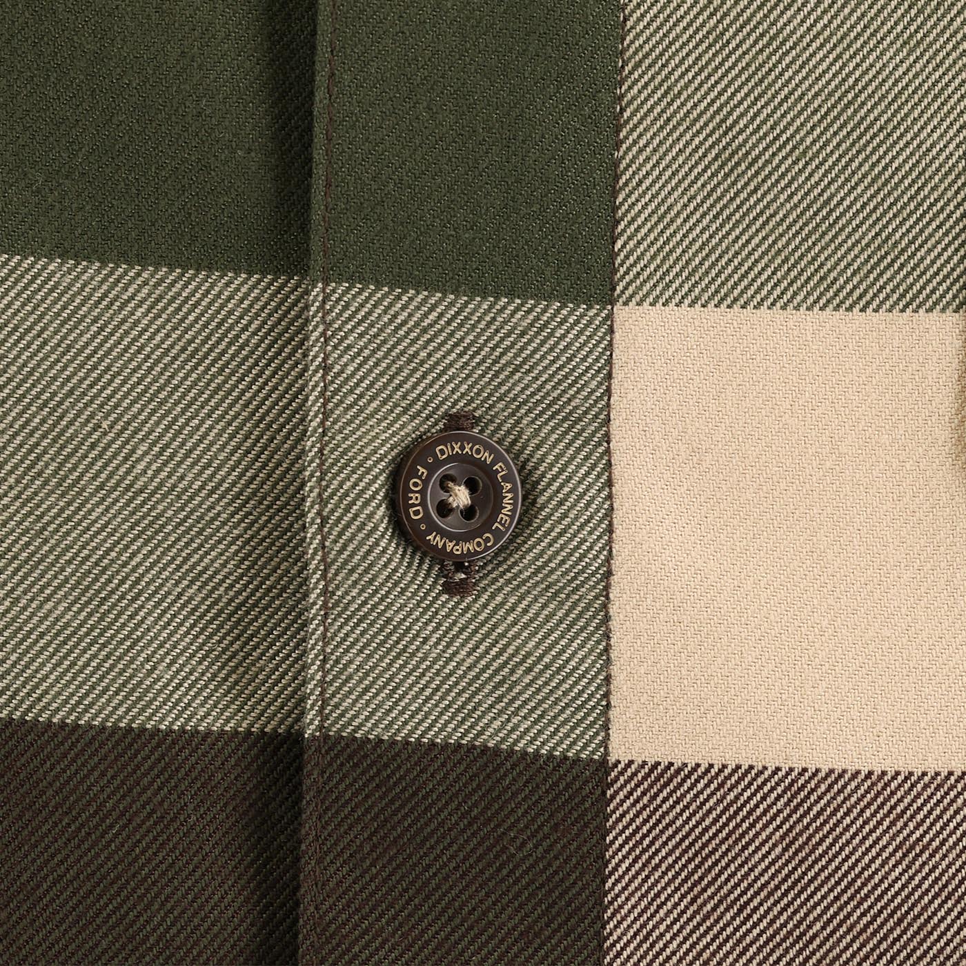Close-up of a checkered fabric with a button featuring 'Dixxon' branding.