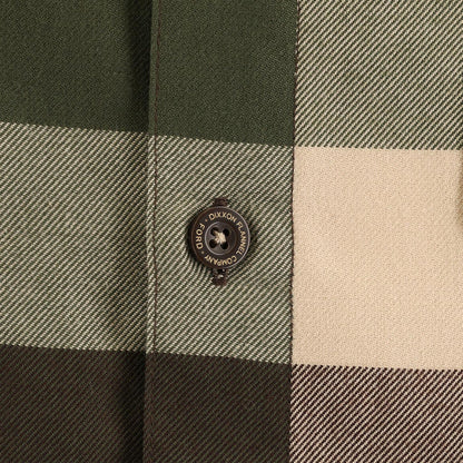 Close-up of a checkered fabric with a button featuring 'Dixxon' branding.