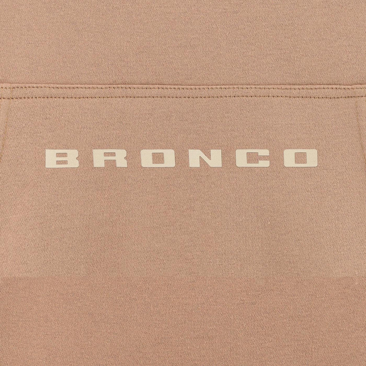 Close-up of a brown fabric surface with 'BRONCO' branding.
