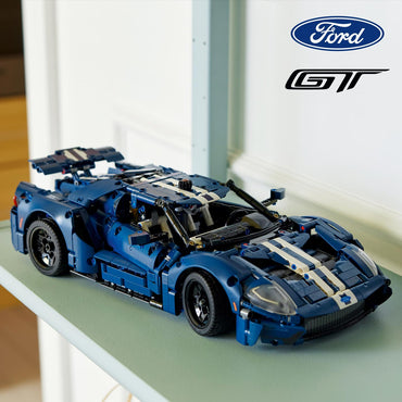 Blue and white model car on a surface with Ford logo above