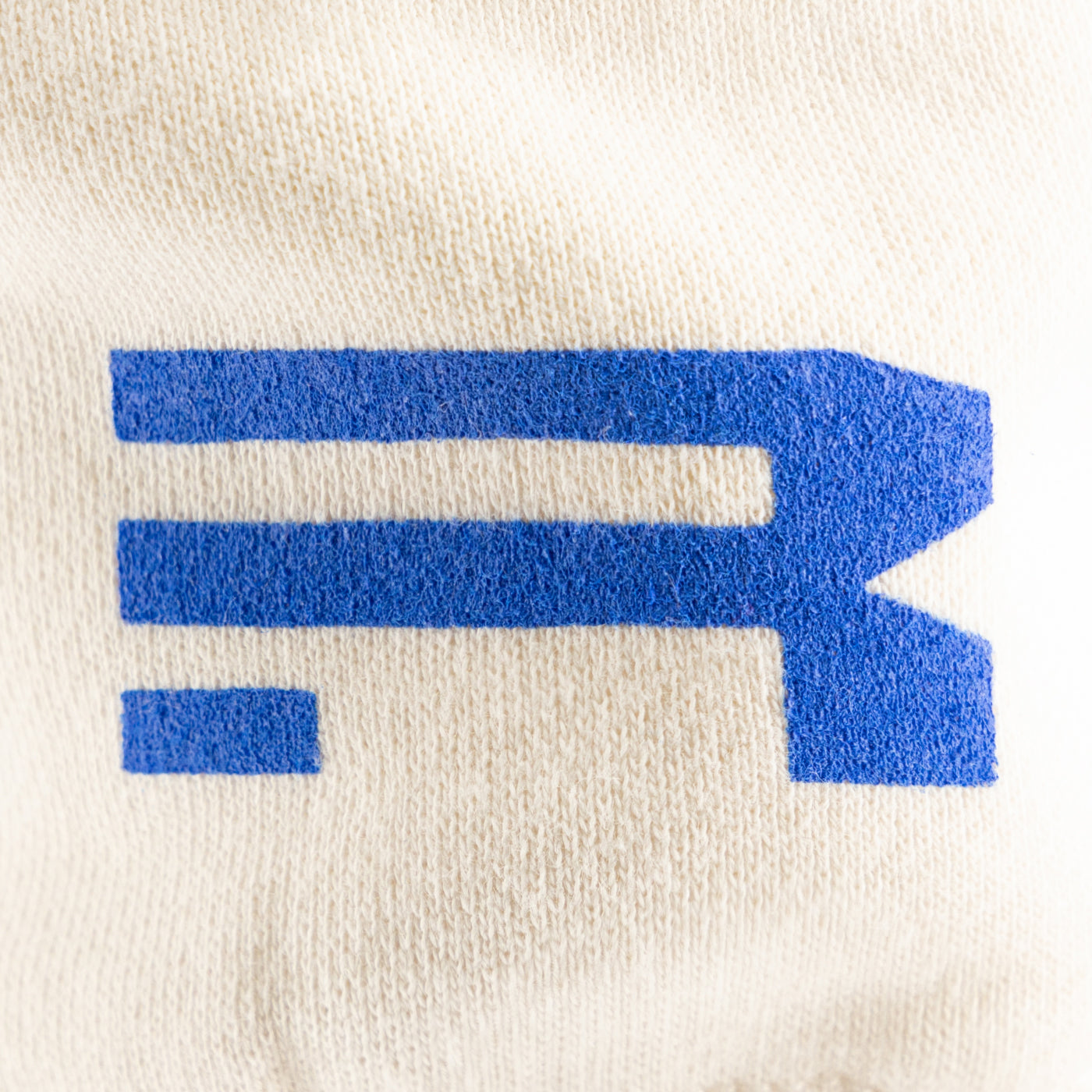 Blue geometric Ford Racing logo on a beige background