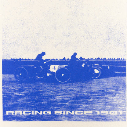 Vintage-style illustration of two people on a motorcycle with 'Racing Since 1901' text.