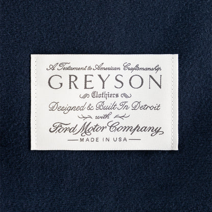 Greyson embroidered white label on a navy blue backround