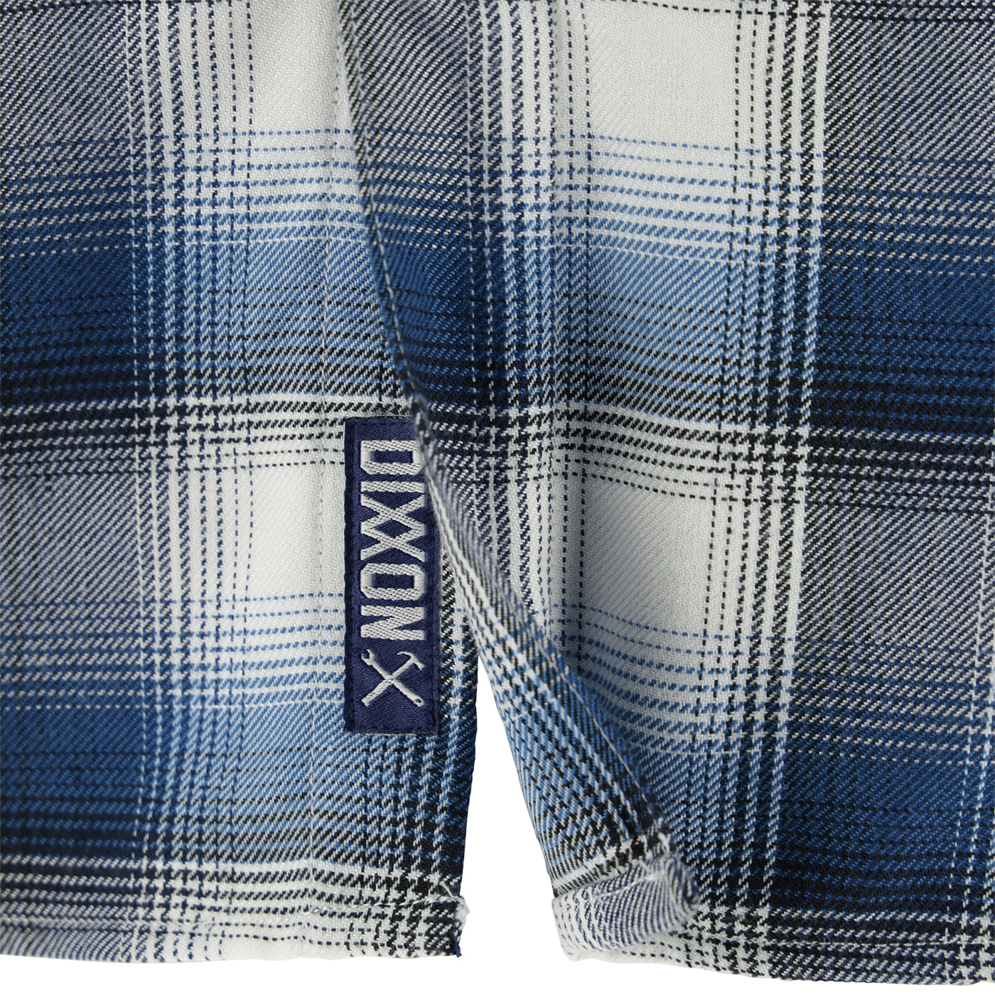 Close-up of a blue and white plaid fabric with a Dixon logo tag.