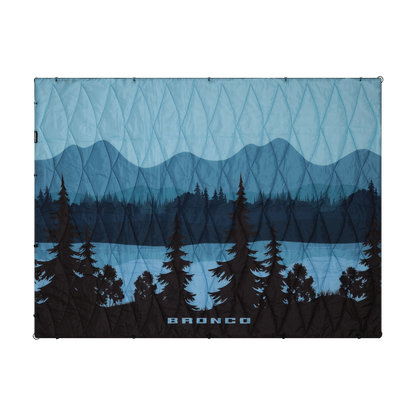 Blue and black patterned puffer blanket with mountain and tree design, featuring the brand 'Bronco'.