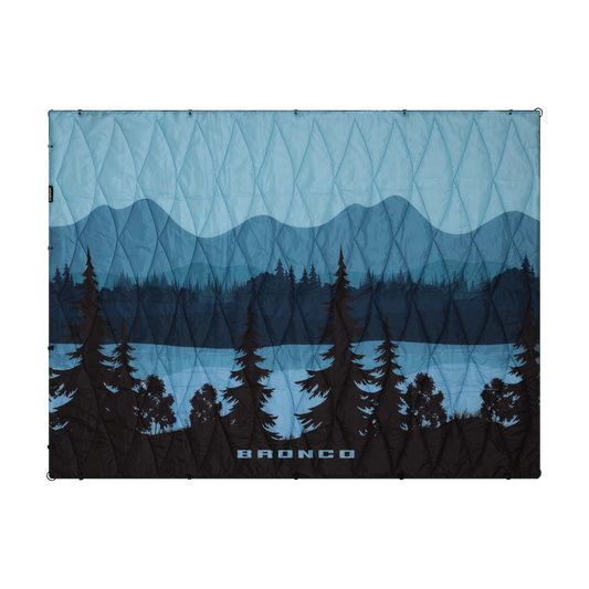 Blue and black patterned puffer blanket with mountain and tree design, featuring the brand 'Bronco'.