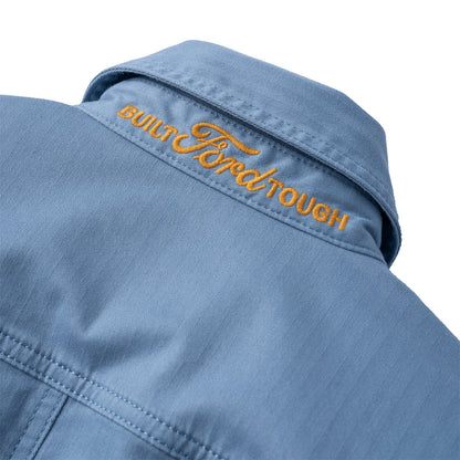 Close-up of a light blue denim-style shirt collar with orange embroidered text reading 'BUILT FORD TOUGH' on a white background.