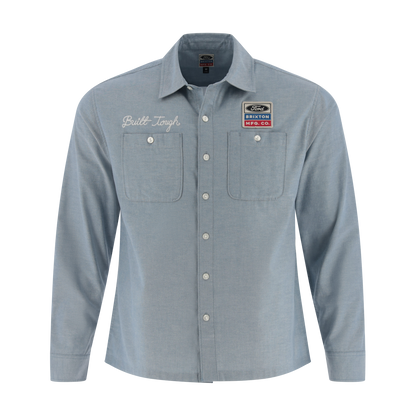 Light blue button-up shirt with embroidered text and patches on a white background