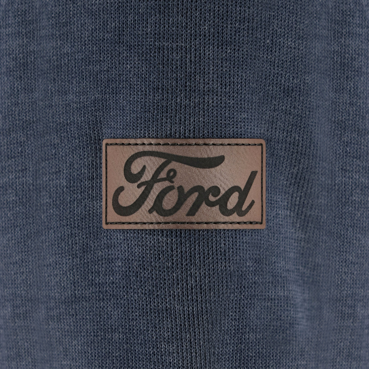 Close-up of a Ford logo patch on a blue fabric background