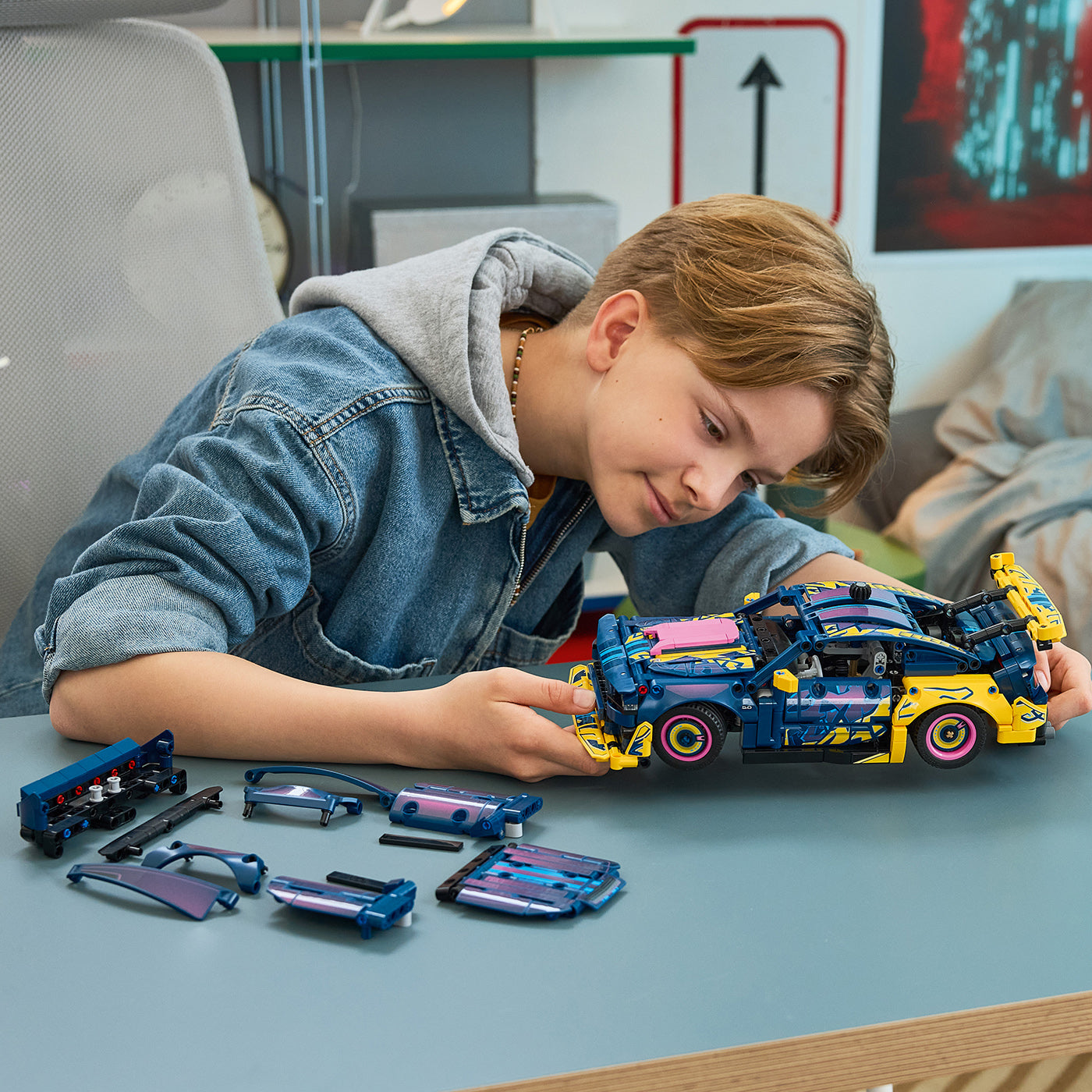 Child playing with a toy car set on a table