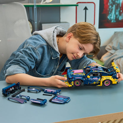 Child playing with a toy car set on a table