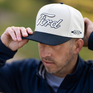 man wearing a hat with 3d white ford script and navy blue embroidery and bill