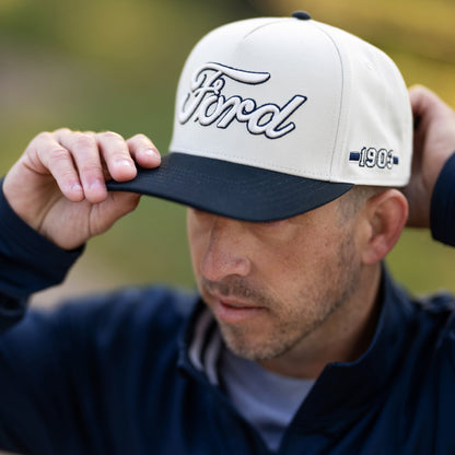 man wearing a hat with 3d white ford script and navy blue embroidery and bill