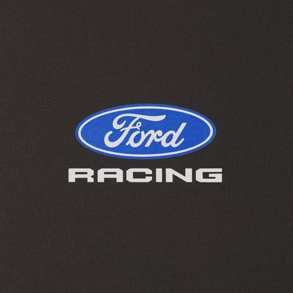 A close-up of a black fabric surface featuring a blue oval Ford logo with white script and the word 'RACING' in white below it.