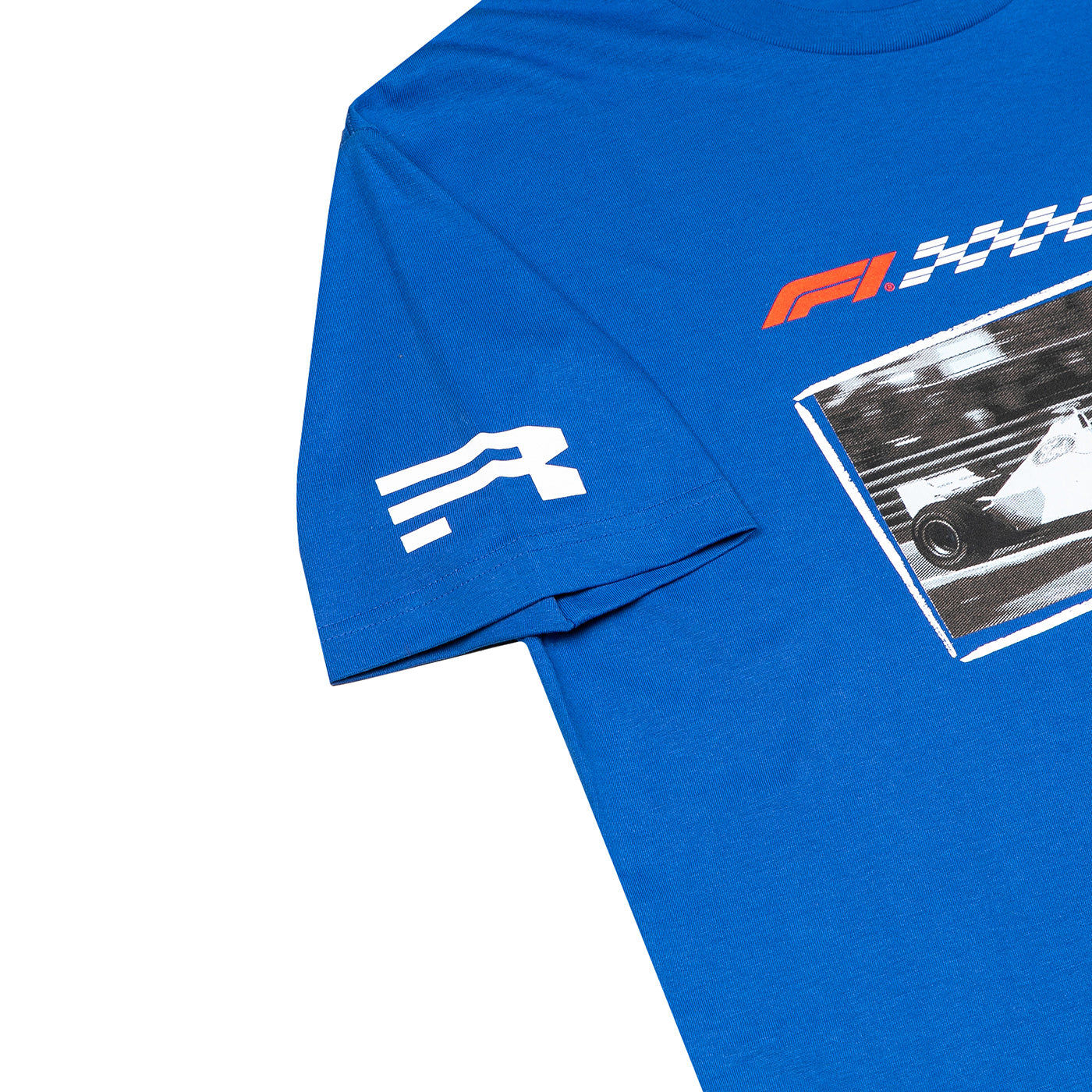 A close-up of a royal blue t-shirt featuring a white stylized 'R' logo on the sleeve and a red, white, and black Formula 1 graphic on the chest.