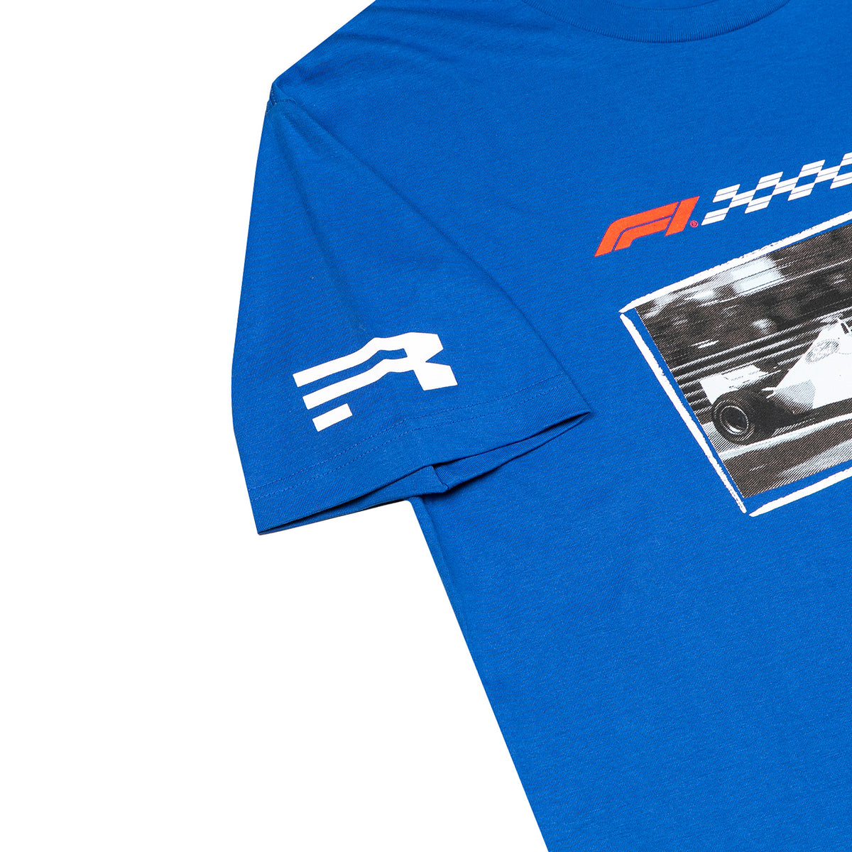A close-up of a royal blue t-shirt featuring a white stylized 'R' logo on the sleeve and a red, white, and black Formula 1 graphic on the chest.