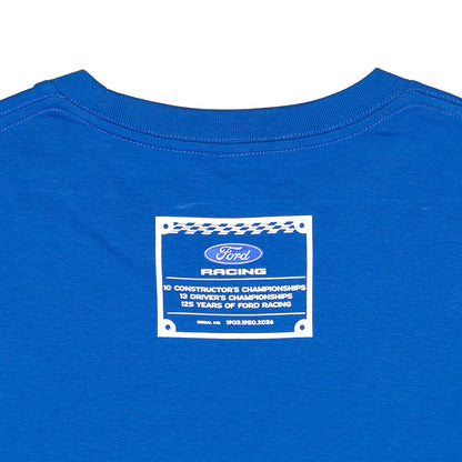 Close-up of the back of a royal blue t-shirt featuring a white and blue Ford Racing graphic patch printed on the center.