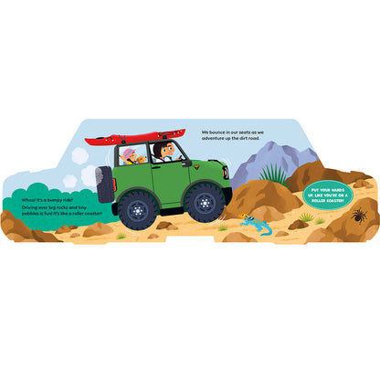 A colorful children's book or activity card illustration showing a green off-road vehicle driving through a dirt landscape with mountains, rocks, and cartoon animals. Speech bubbles and printed text are visible on the scene.