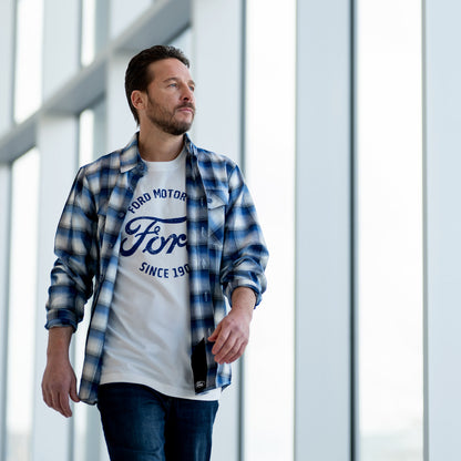 Man wearing a blue and white checkered shirt over a white t-shirt with Ford logo.