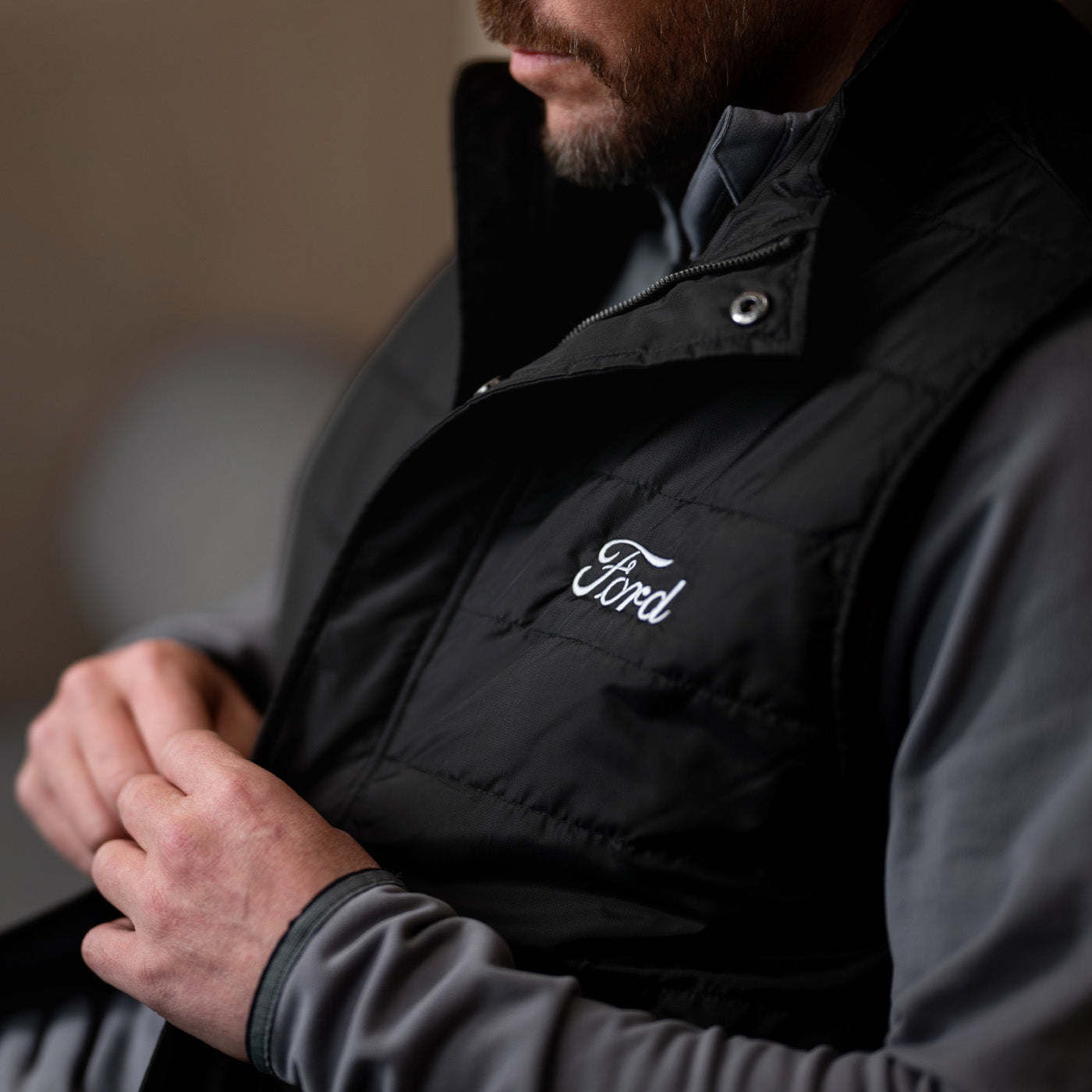 Person wearing a black Ford vest with a blurred background