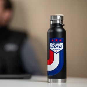 Black water bottle with Ford logo on a blurred background